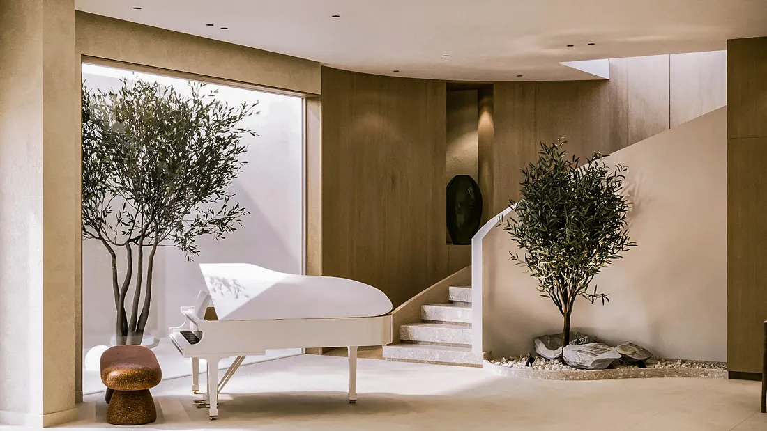 AK Home white grand piano beside the curved staircase